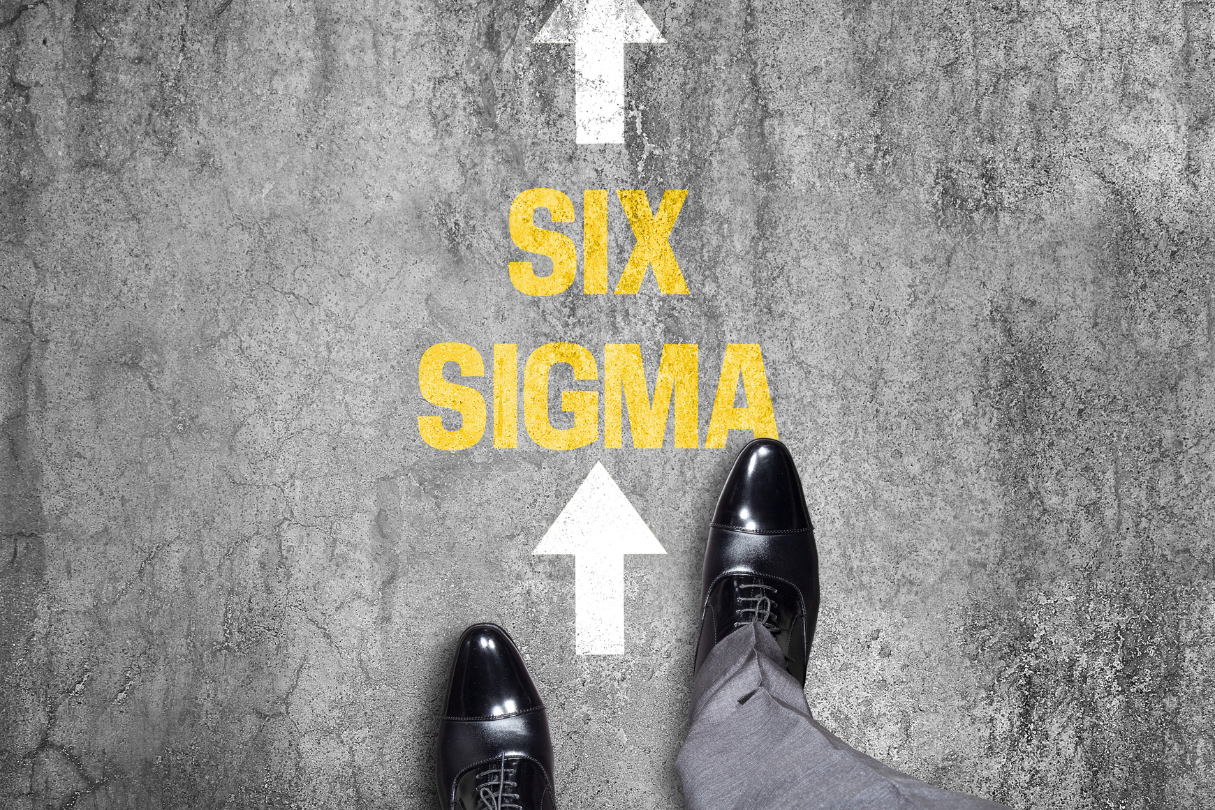 Top view of a businessman following Six Sigma text